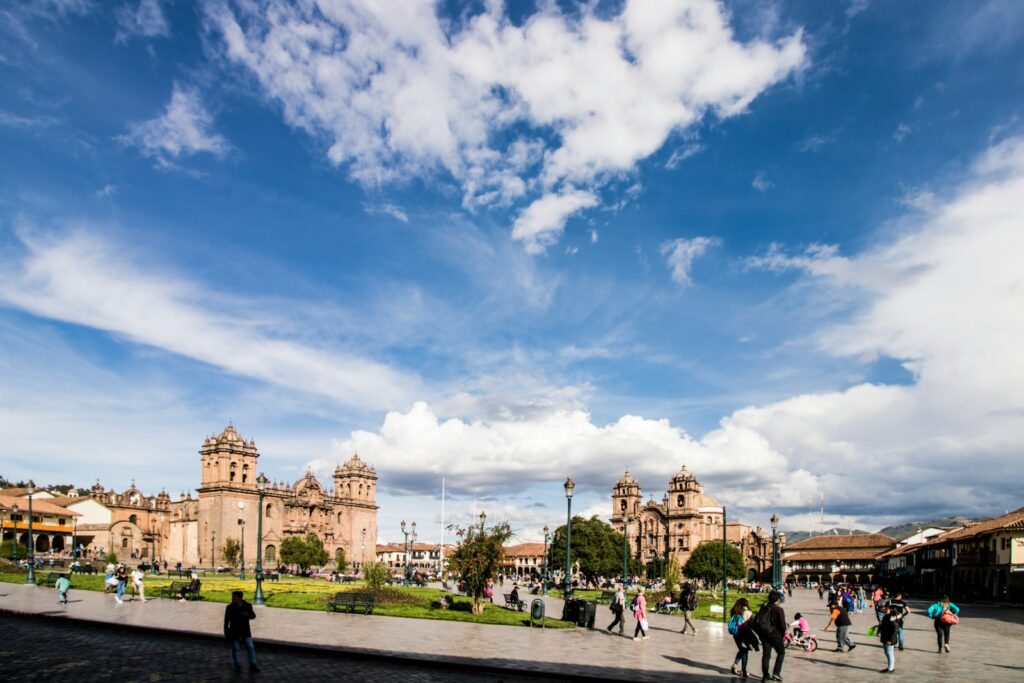 people walking on street near brown concrete building under blue sky during daytime
